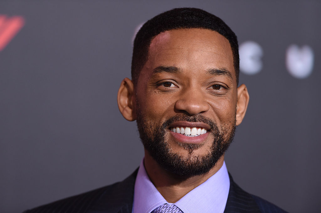 Will Smith smiling in front of a black background