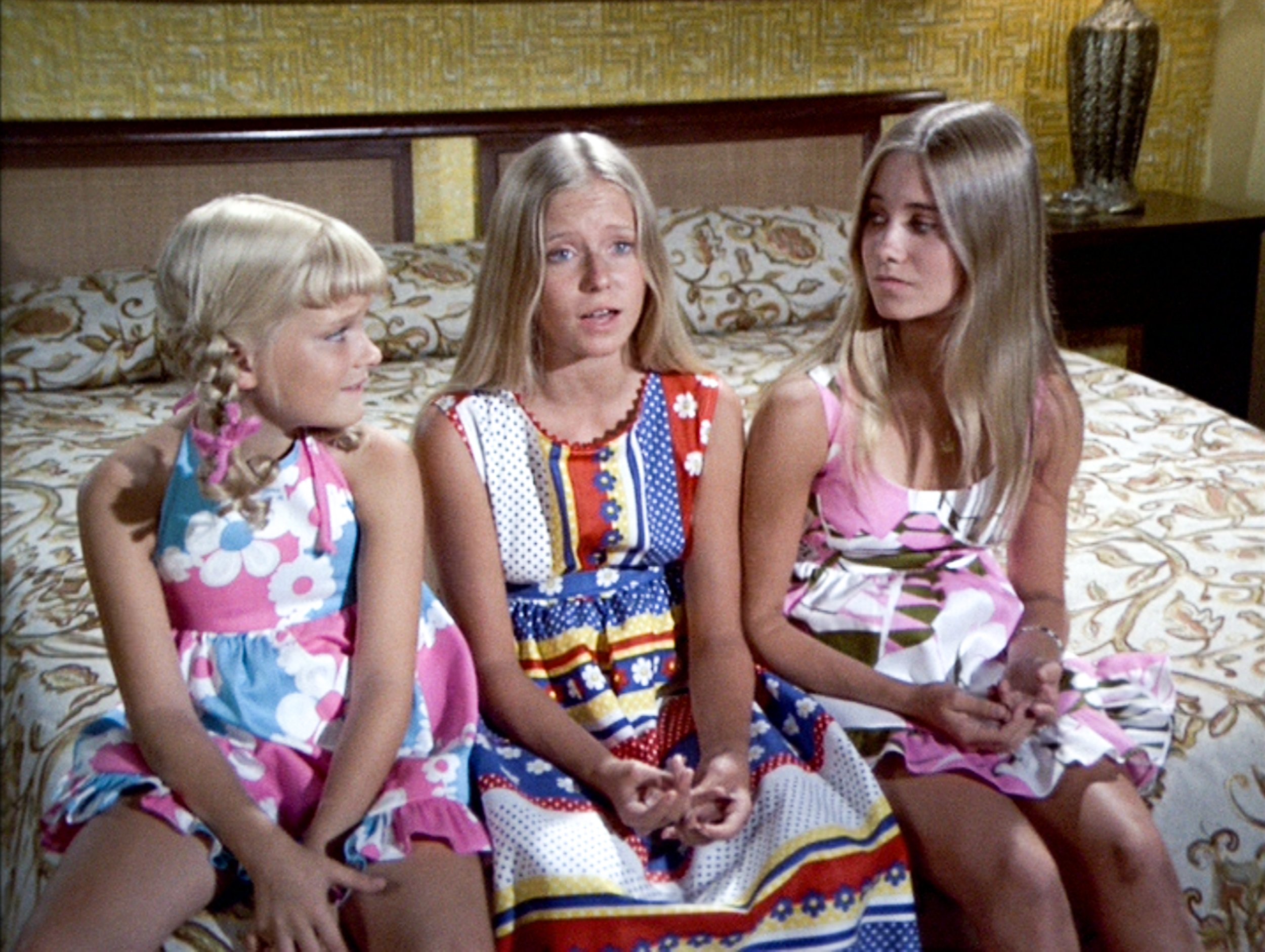 Susan Olsen, Eve Plumb, and Maureen McCormick on a bed in a scene from The Brady Bunch