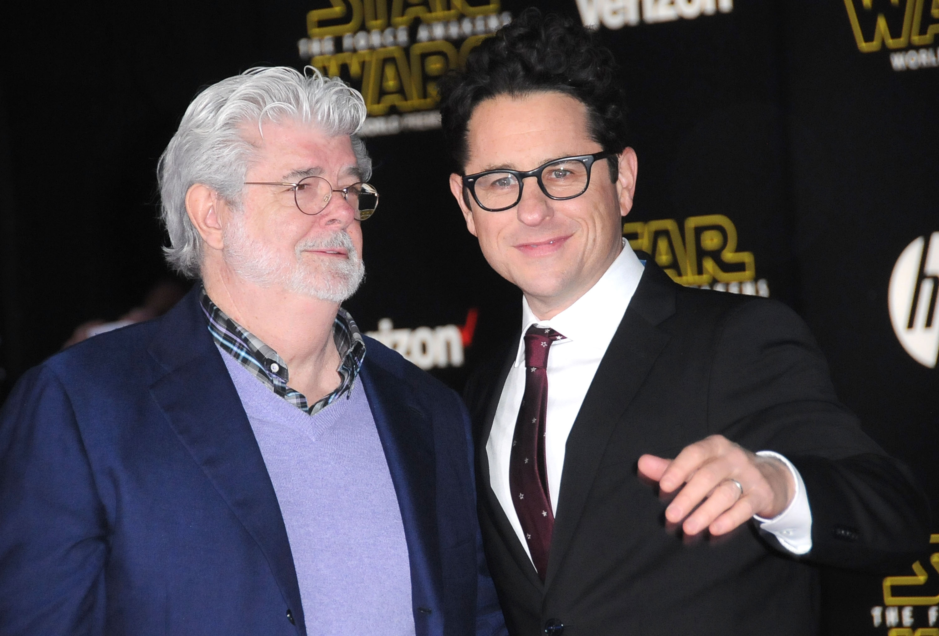 George Lucas and J. J. Abrams in front of a black background