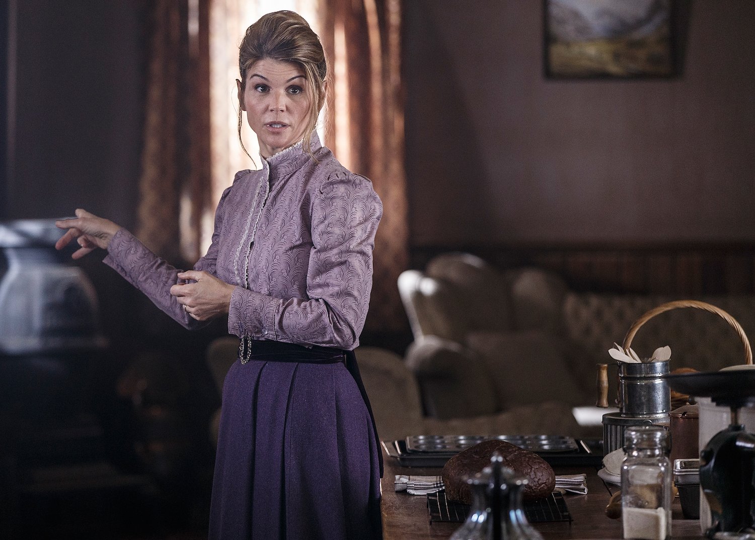 Lori Loughlin, in a purple blouse and skirt, shooting a scene for When Calls the Heart 