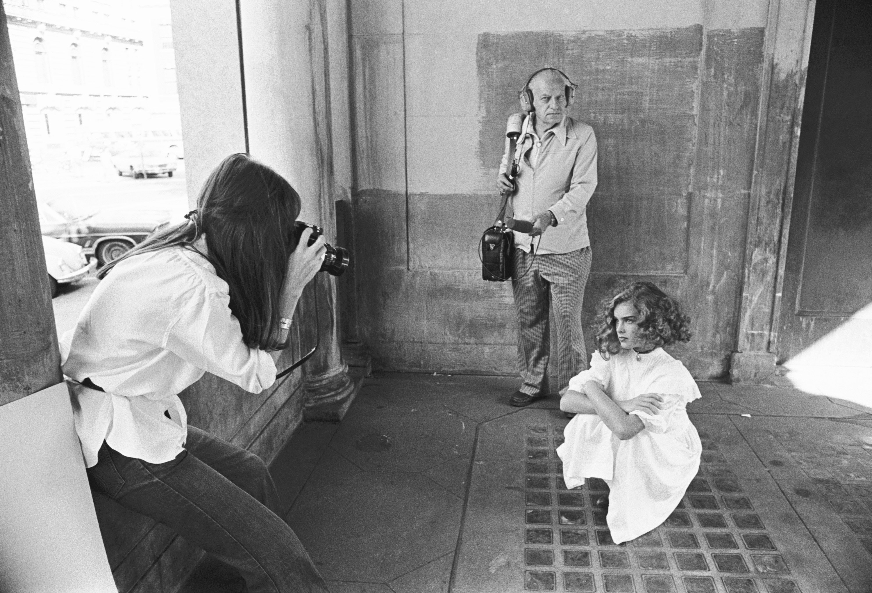 Brooke Shields near someone with a camera on the set of Pretty Baby