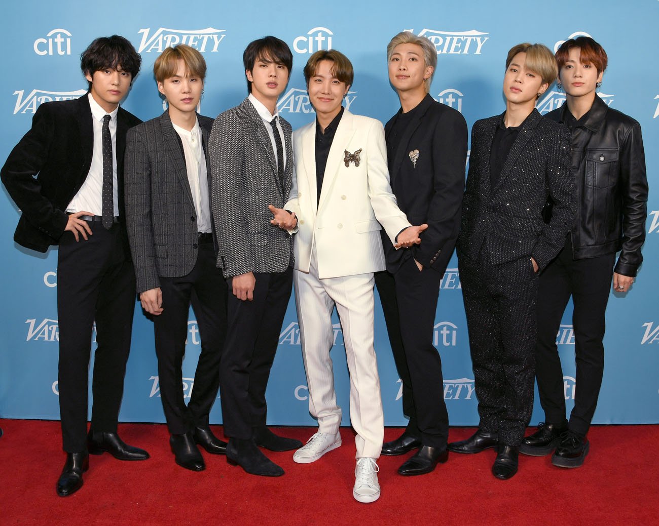 BTS standing on the red carpet in front of blue background