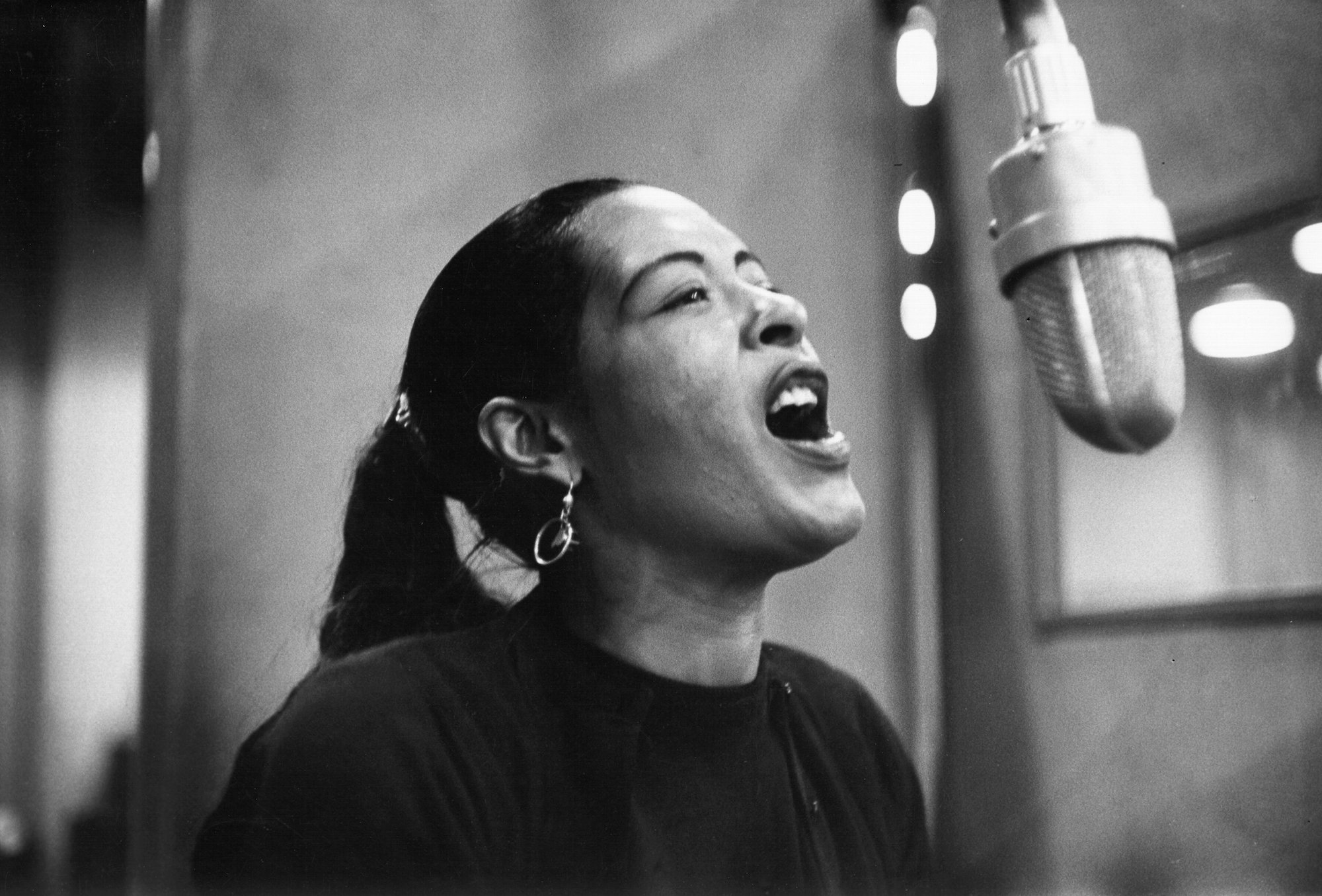 Billie Holiday singing into a microphone