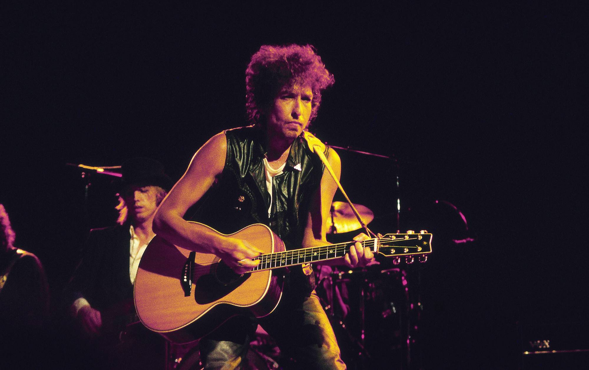 Bob Dylan on stage, playing guitar