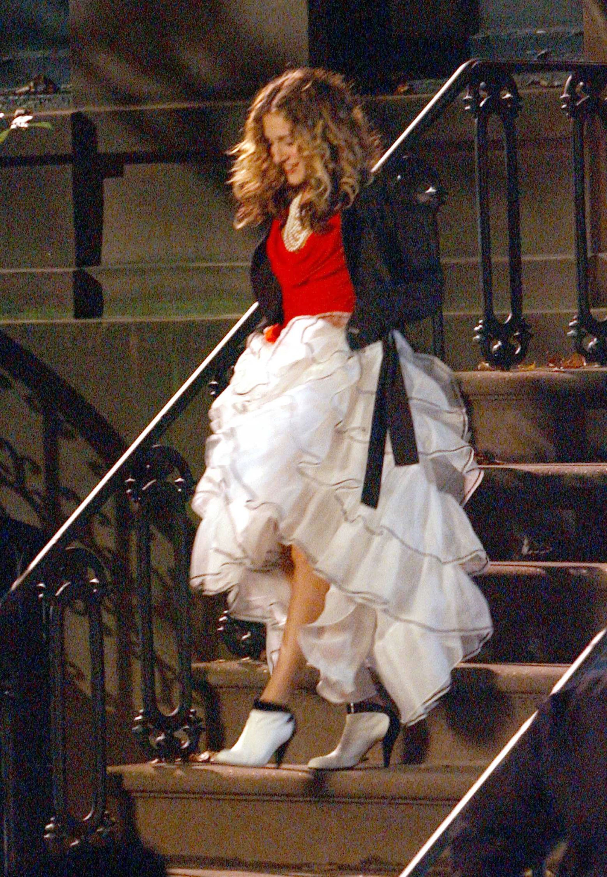 Sarah Jessica Parker as Carrie Bradshaw walks down the steps of her apartment