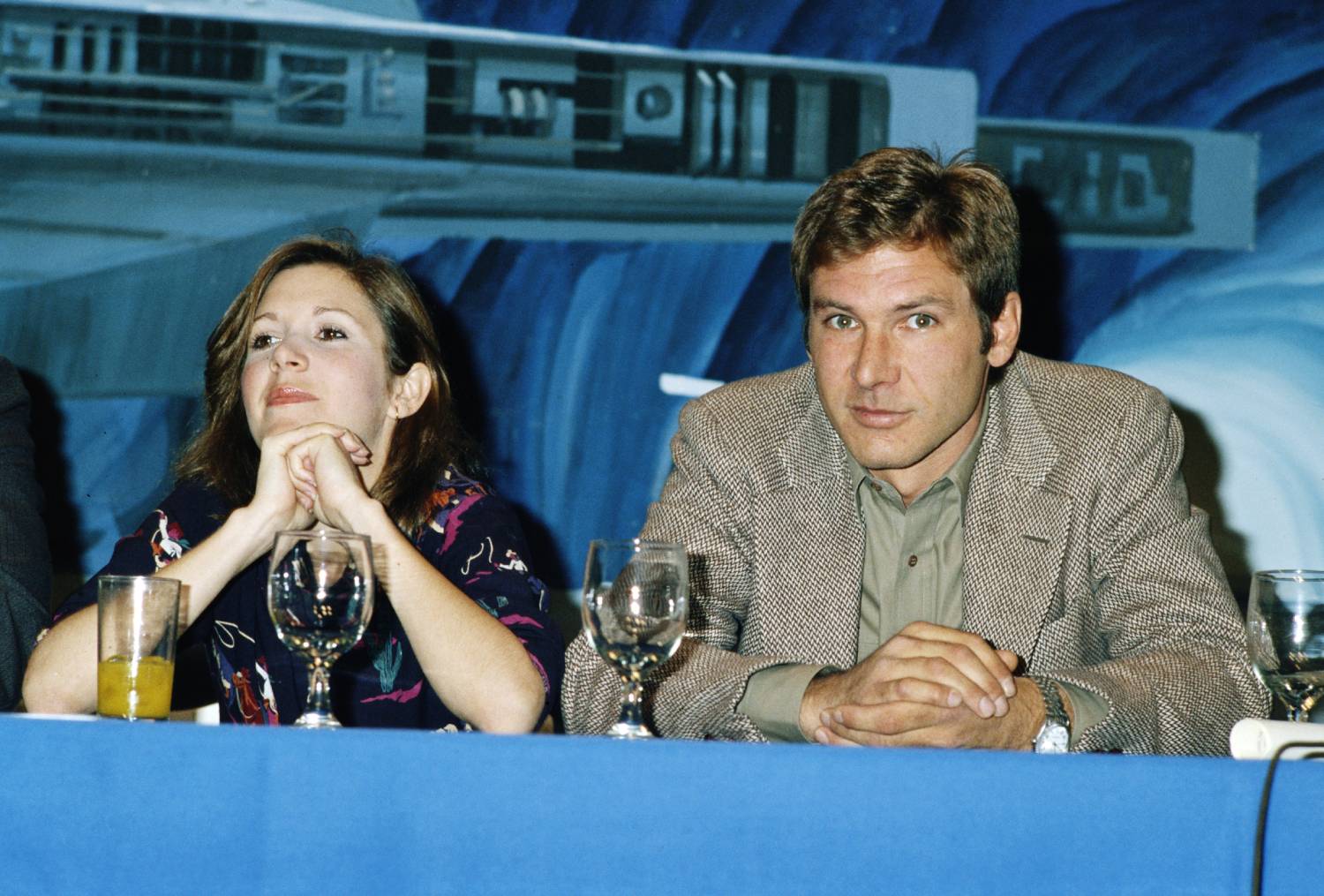 American actors Carrie Fisher and Harrison Ford at a press conference for one of the 'Star Wars' films, circa 1980.