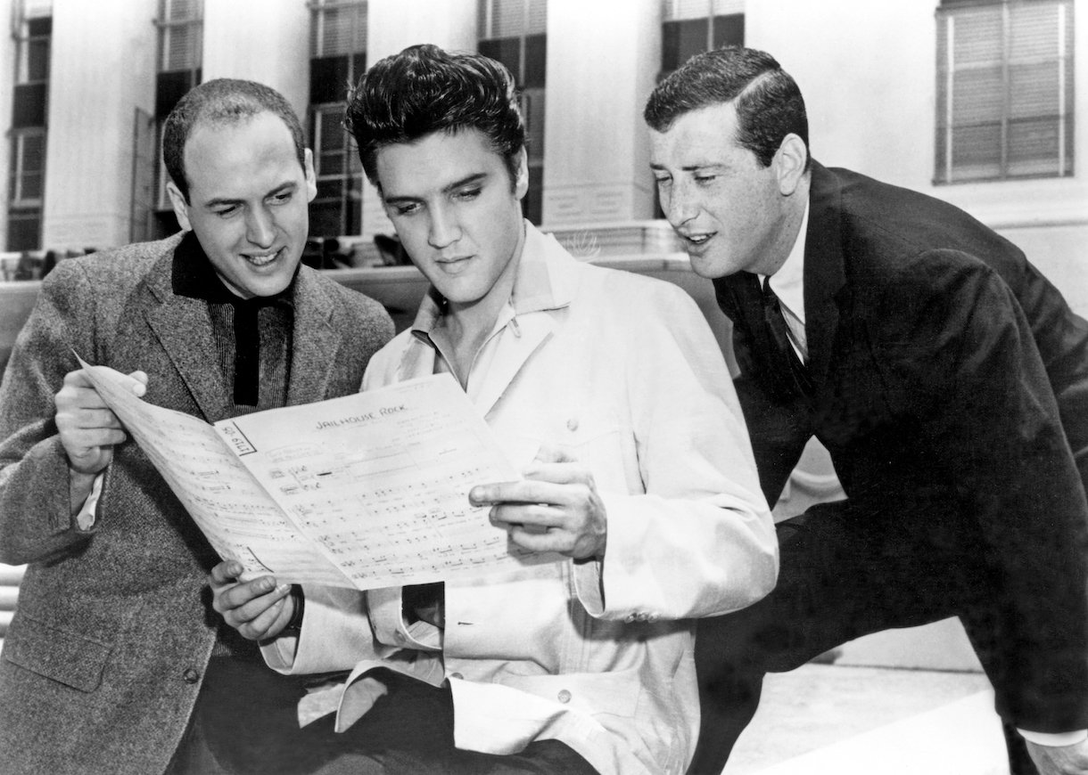 Elvis Presley with songwriters Leiber and Stoller looking over the sheet music for Jailhouse Rock at Metro-Goldwyn-Mayer Studios in 1957 in Culver City