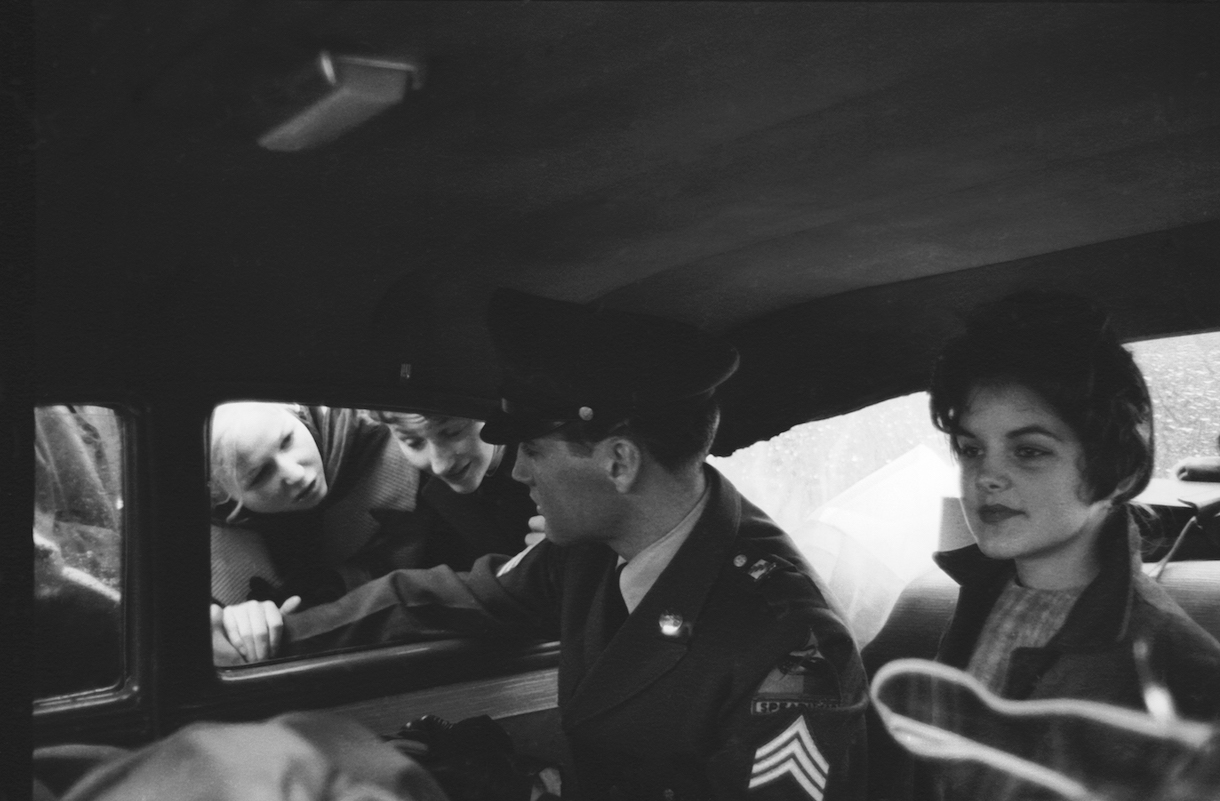 Elvis Presley in uniform, in backseat of car with girlfriend, 16-yr. old Priscilla Beaulieu