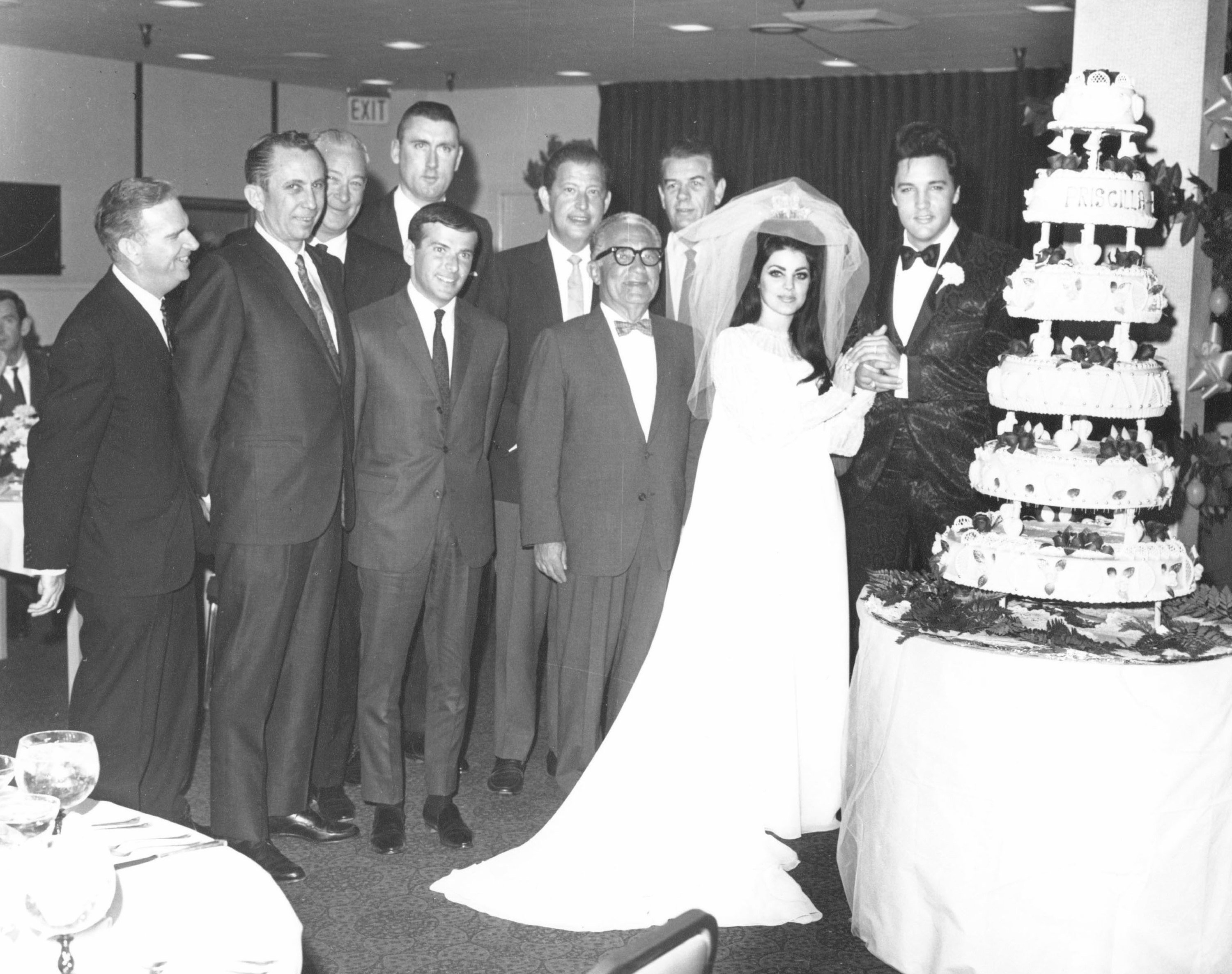 Elvis and Priscilla Presley near a cake