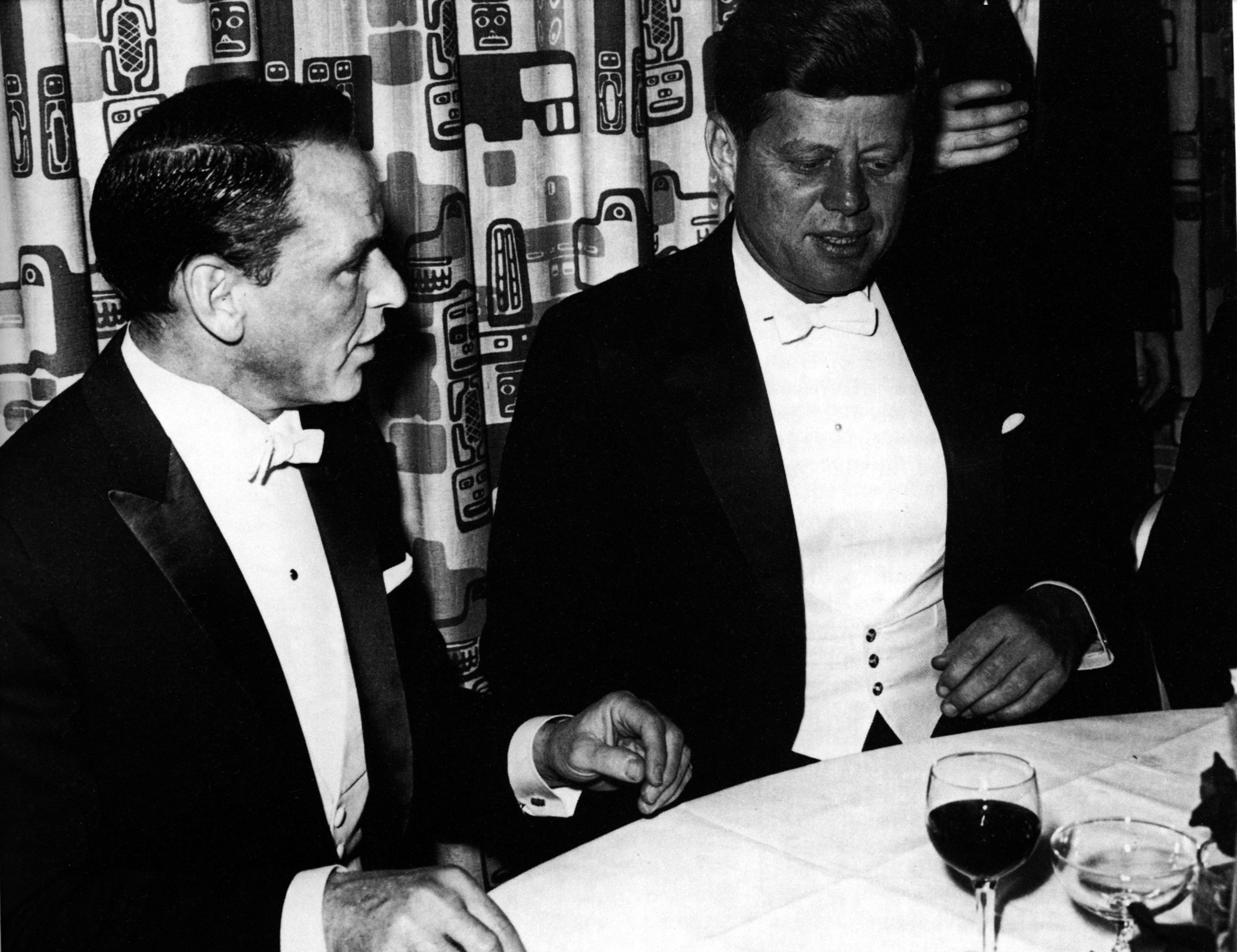 Frank Sinatra and John F. Kennedy sitting at a table together