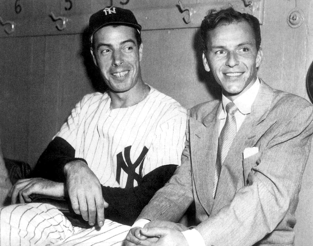 Joe DiMaggio (left) sits with Frank Sinatra at Yankee Stadium in 1949