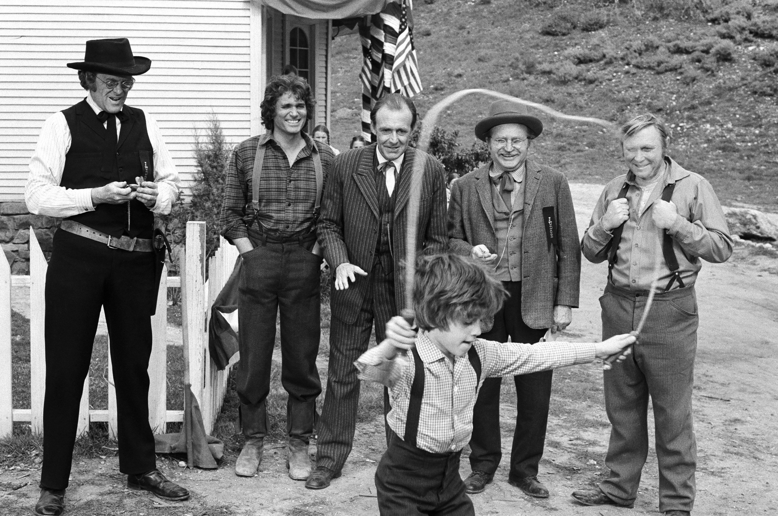 (L-R) Kevin Hagen as Doctor Hiram Baker, Michael Landon as Charles Ingalls, Richard Bull as Nels Oleson, Karl Swenson as Lars Hanson, Wayne Heffley as Mr. Kennedy, Jonathan Gilbert as Willie Oleson (front) | George Hurrell/NBCU Photo Bank