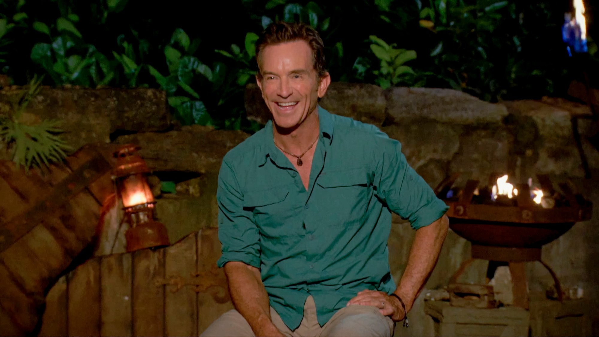 Jeff Probst smiling, sitting at tribal council