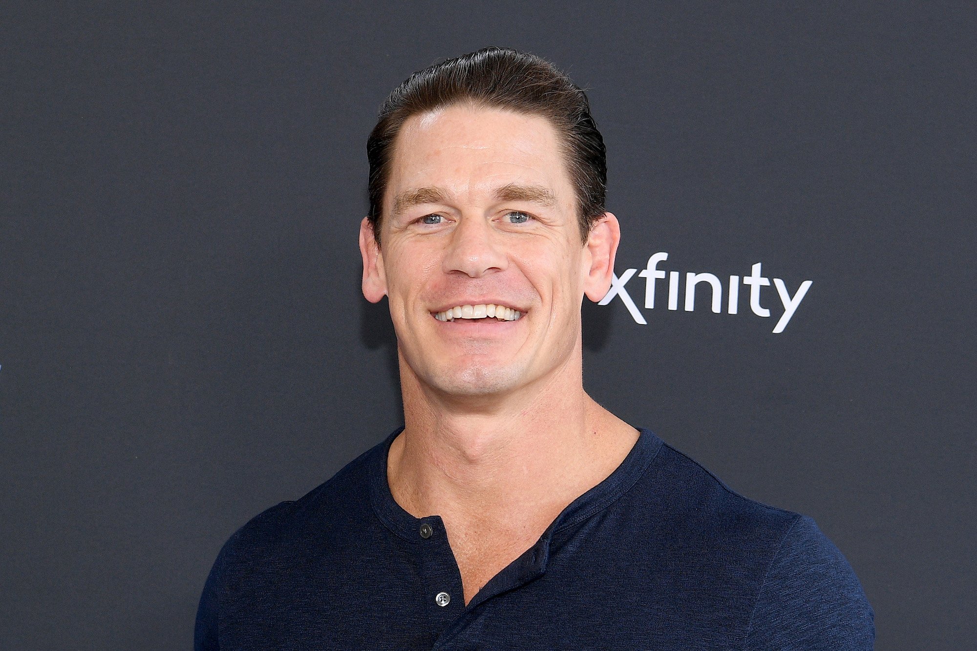 John Cena smiling in front of a black background