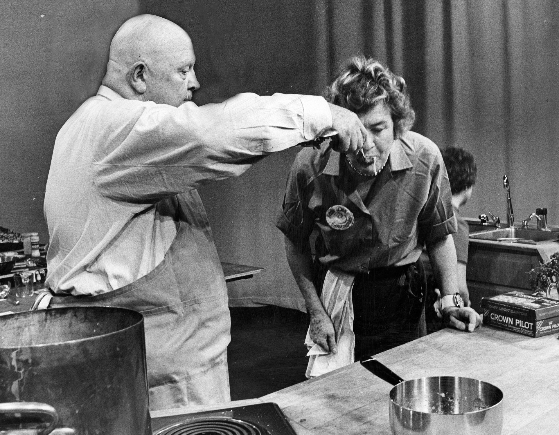 James Beard feeds Julia Child during the 1968 Fish Expo at the WGBH-TV studio in Boston