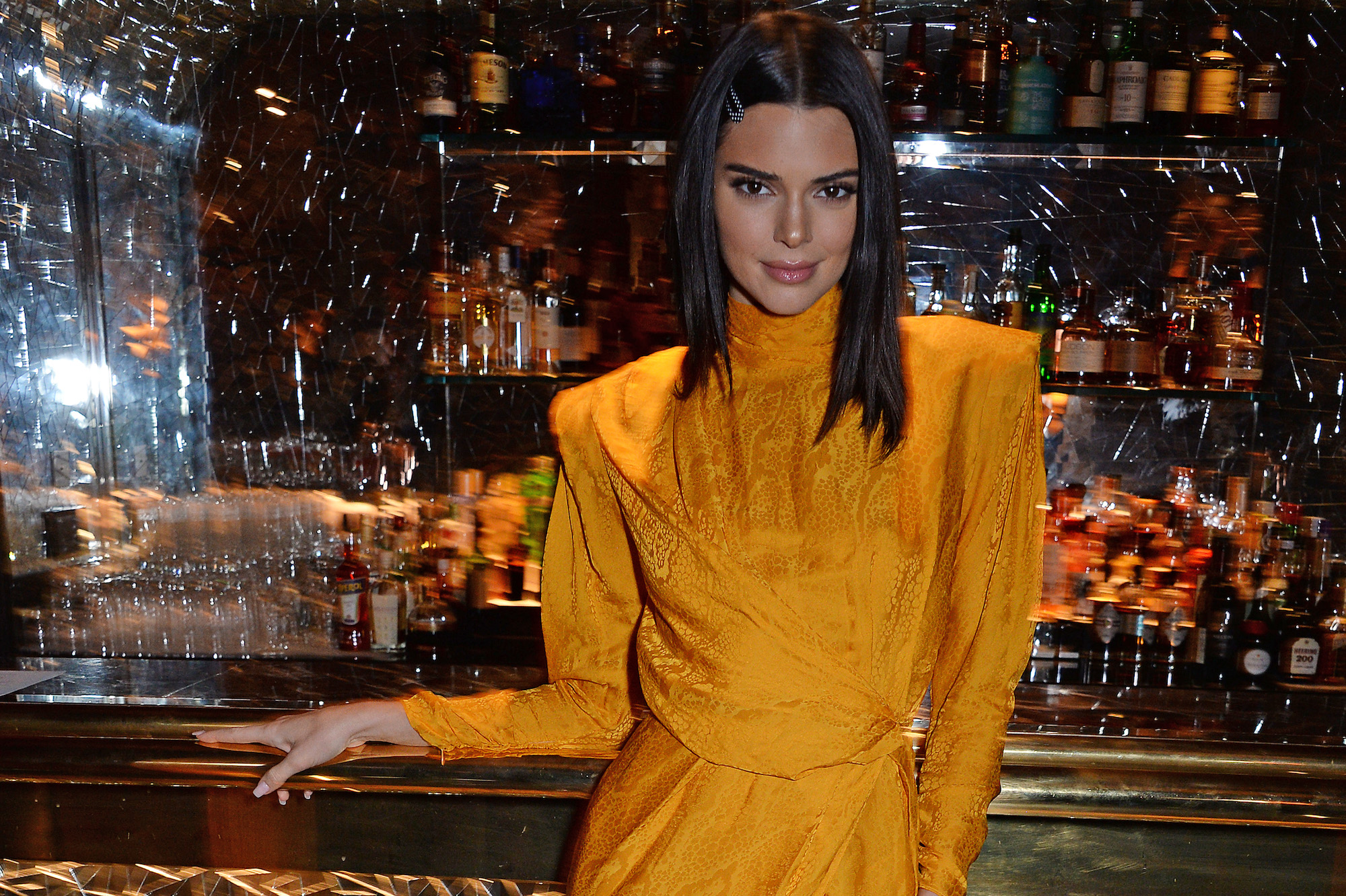 Kendall Jenner smiling in front of a bar