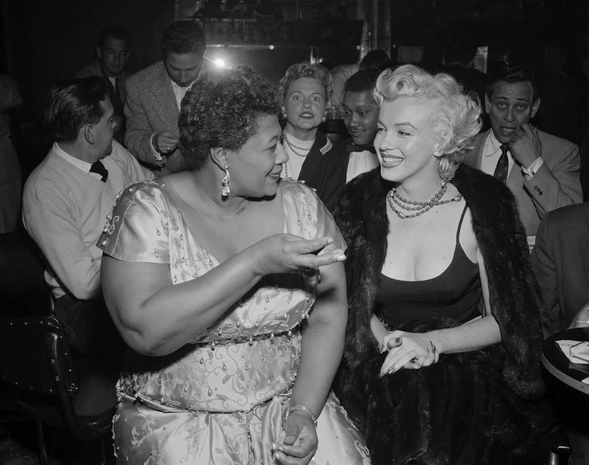 (L-R) Ella Fitzgerald and Marilyn Monroe turned to each other, laughing