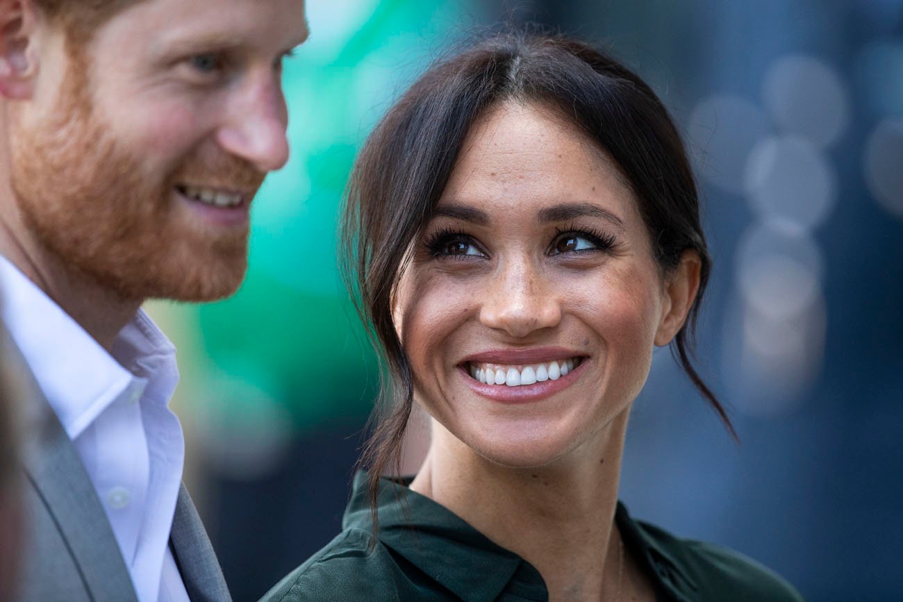 Meghan Markle smiles as she looks at Prince Harry