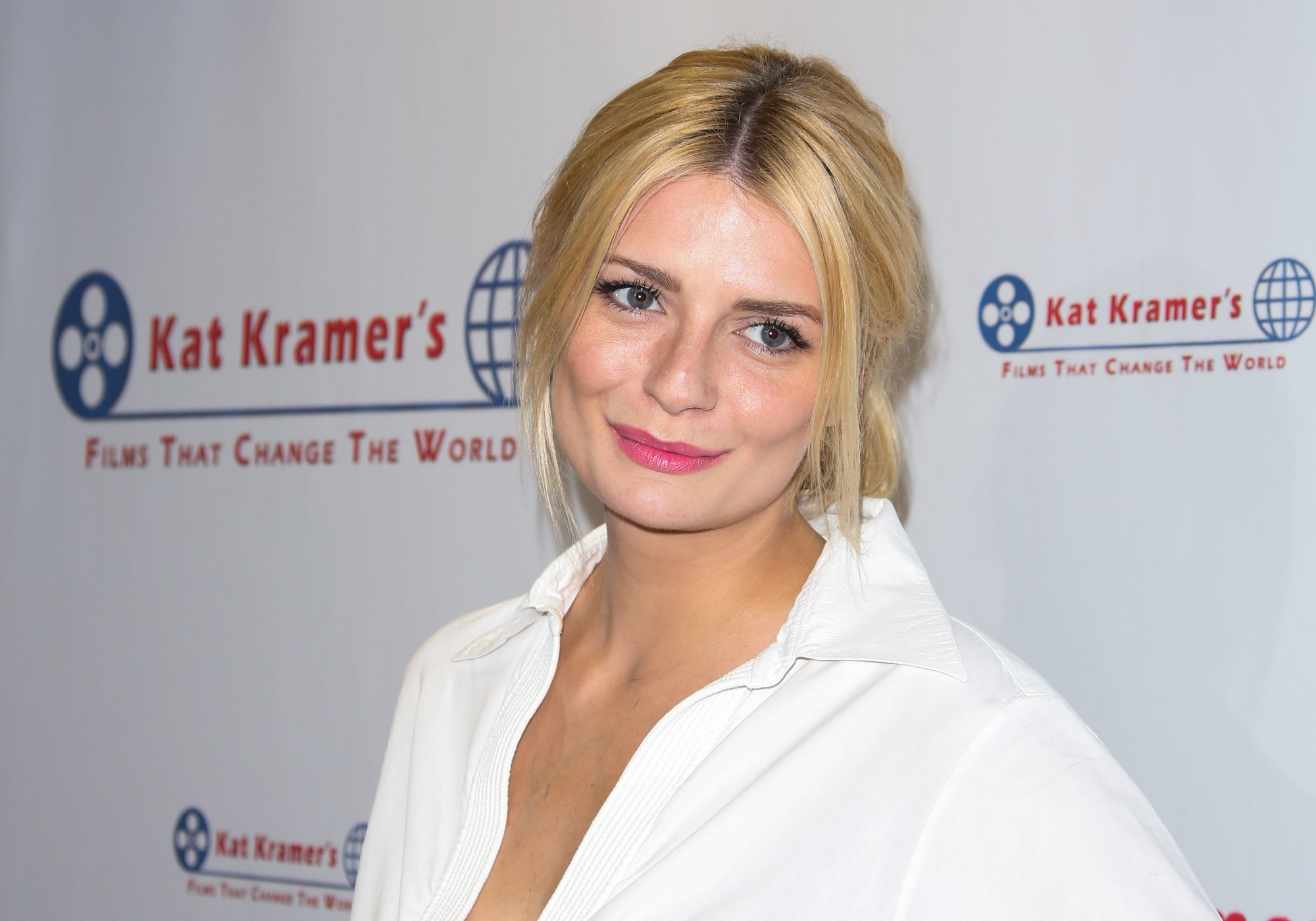 Mischa Barton smiling in front of a white background