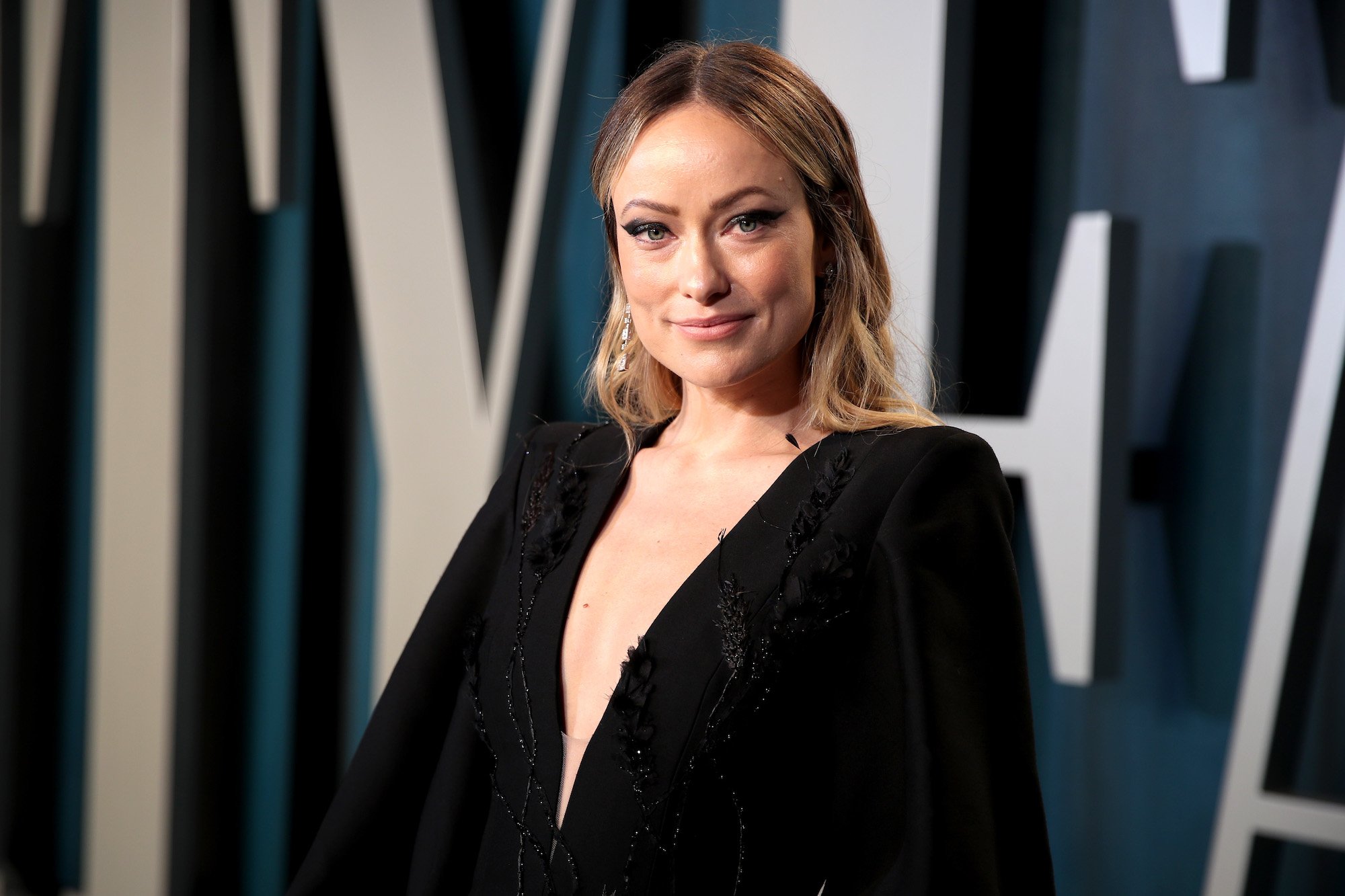 Olivia Wilde smiling in front of a blurred background