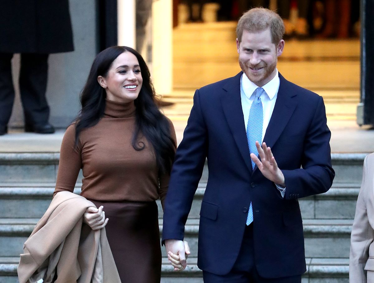 Prince Harry and Meghan Markle hold hands as they leave Canada House in 2020