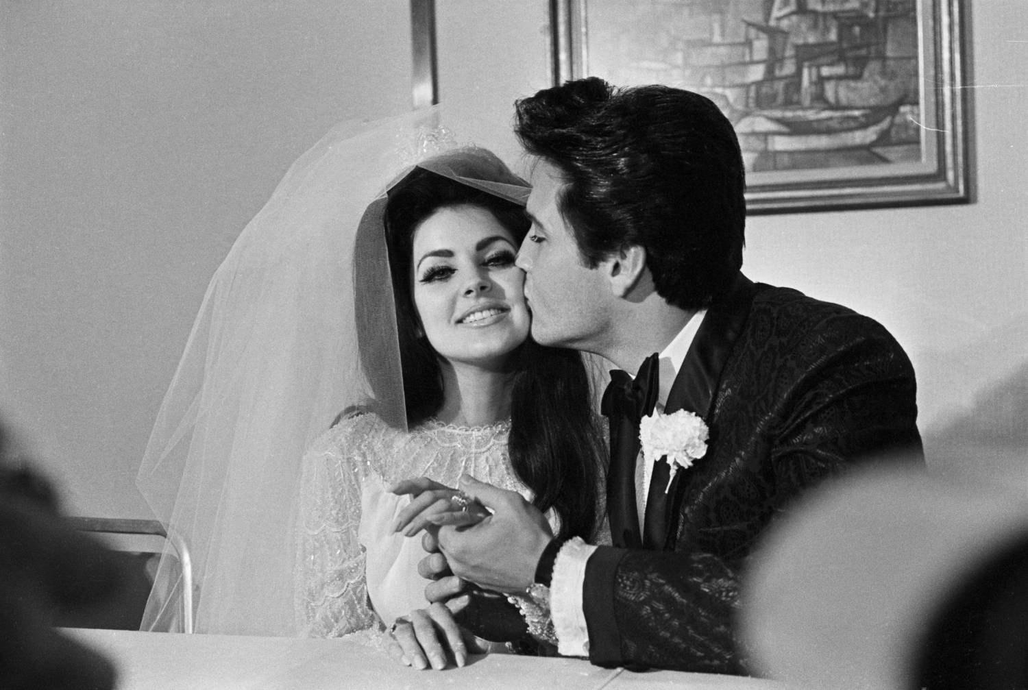 Las Vegas, NV: Elvis Presley gives his new bride, Priscilla Ann Beaulieu, a kiss following their wedding. The bride wears a large diamond on her finger.