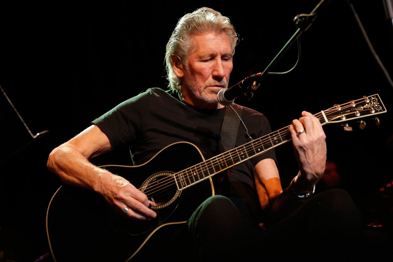 Roger Waters playing guitar on stage