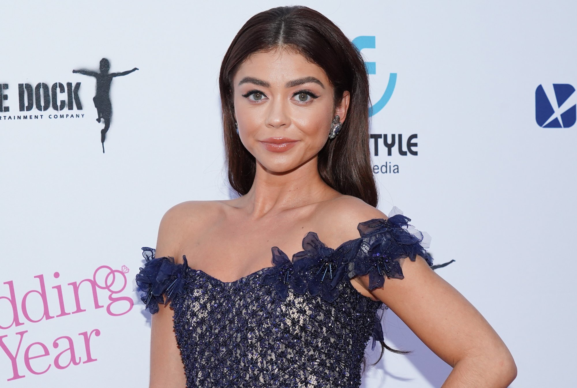 Sarah Hyland smiling in front of a white background