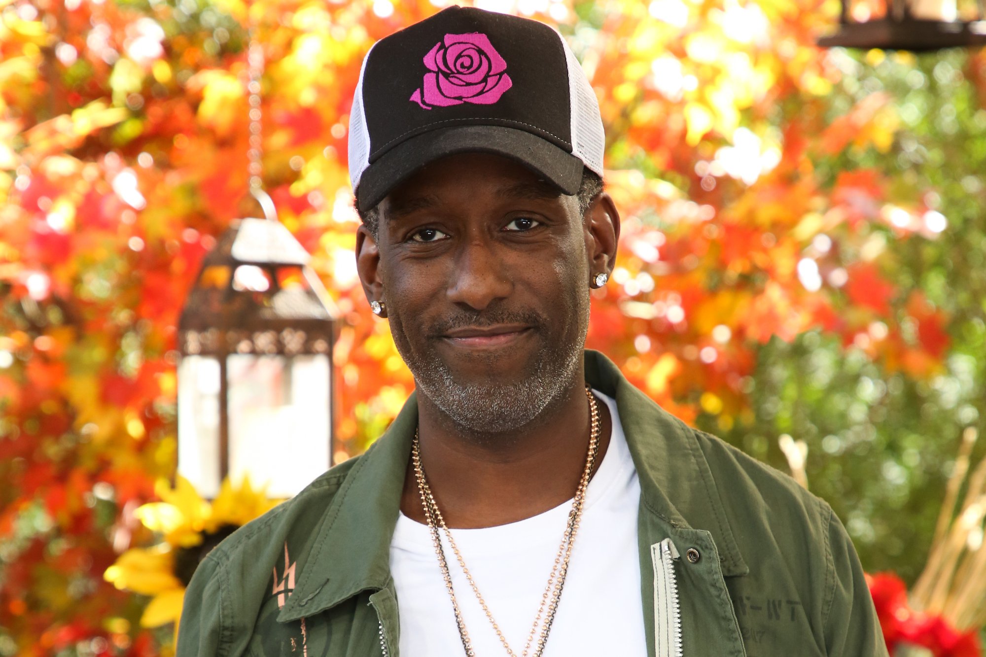 Shawn Stockman smiling in front of fall foliage