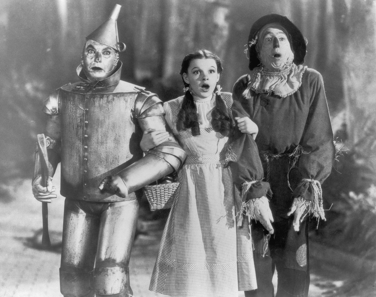 The Tin Man (Jack Haley), Dorothy (Judy Garland) and the Scarecrow (Ray Bolger) set off on their quest for fulfillment in the children's classic 'The Wizard of Oz', directed by Victor Fleming for MGM, 1939
