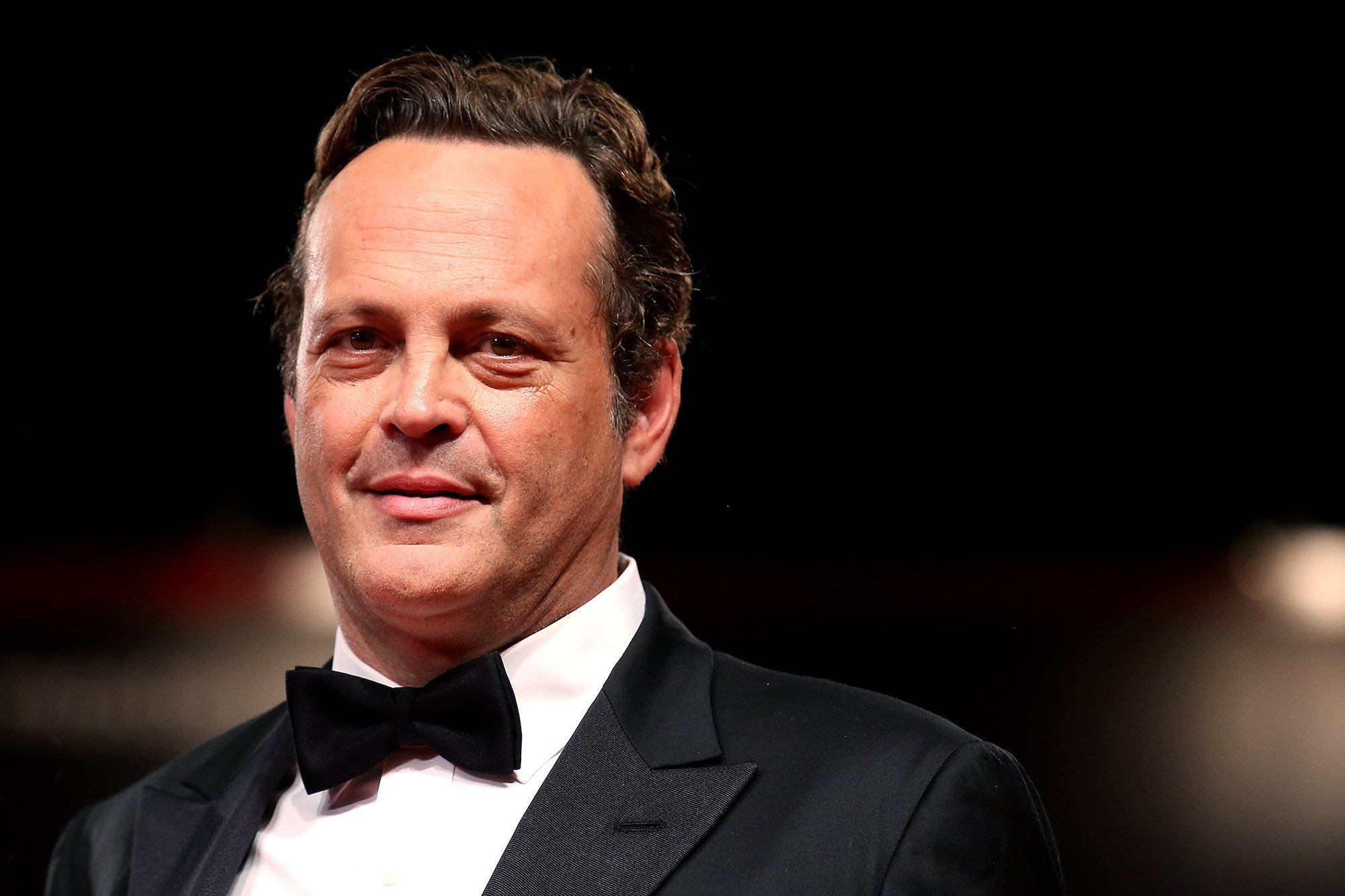 Vince Vaughn smiling in front of a black background