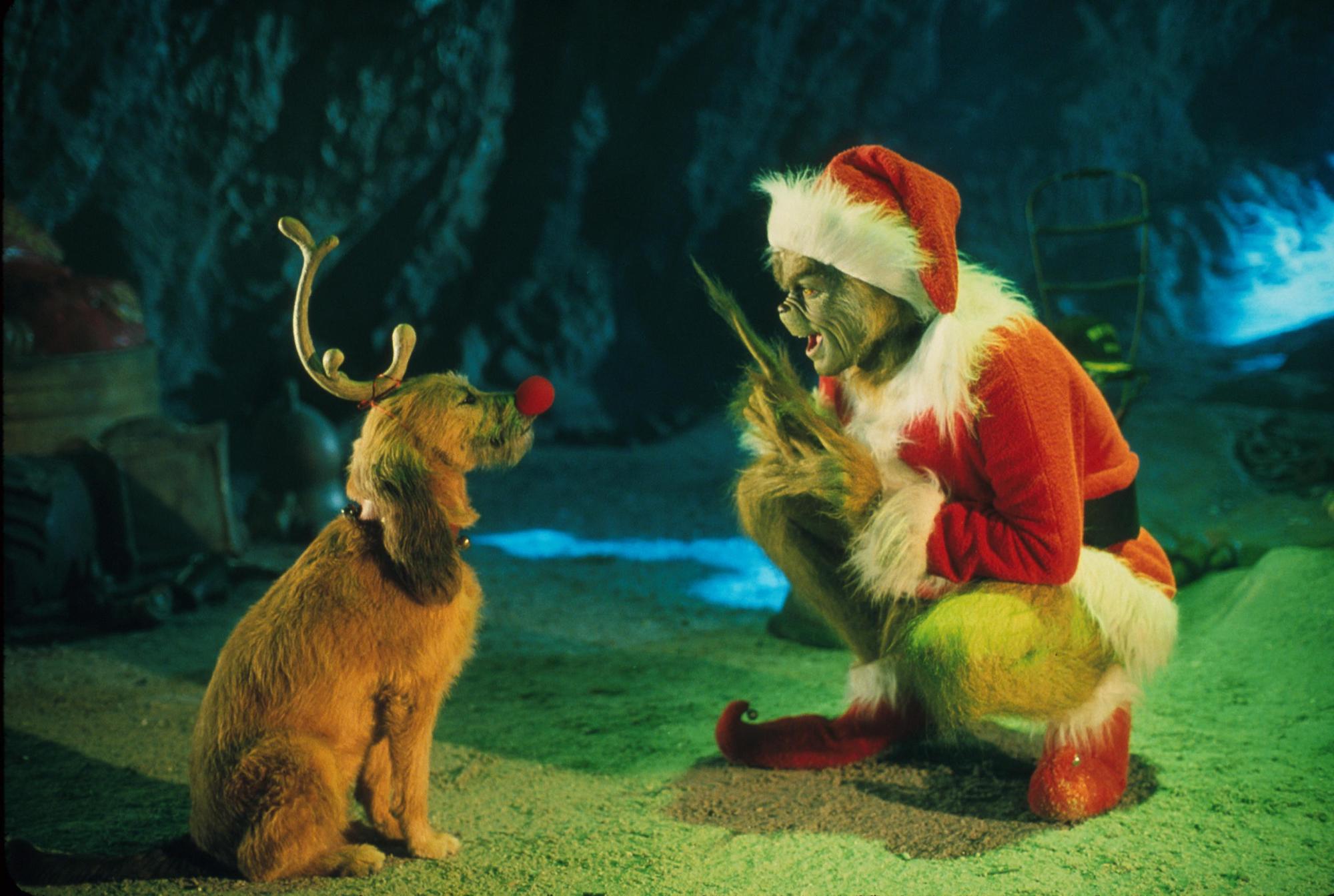 The Grinch, Played By Jim Carrey, Conspires With His Dog Max To Deprive The Whos Of Their Favorite Holiday In 'Dr. Seuss' How The Grinch Stole Christmas," Directed By Ron Howard 