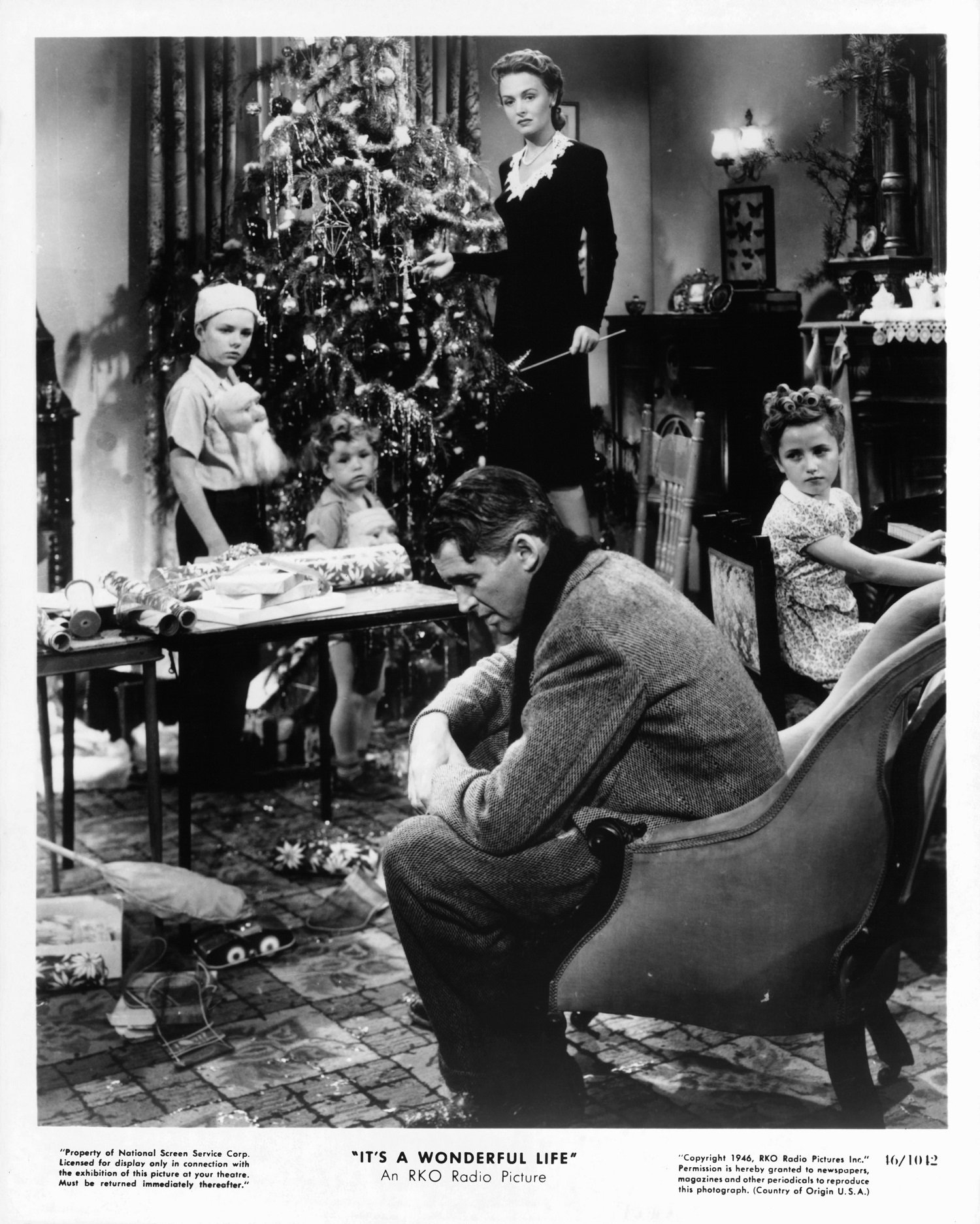 James Stewart sits while Donna Reed looks to him in a scene from the film 'It's A Wonderful Life' 