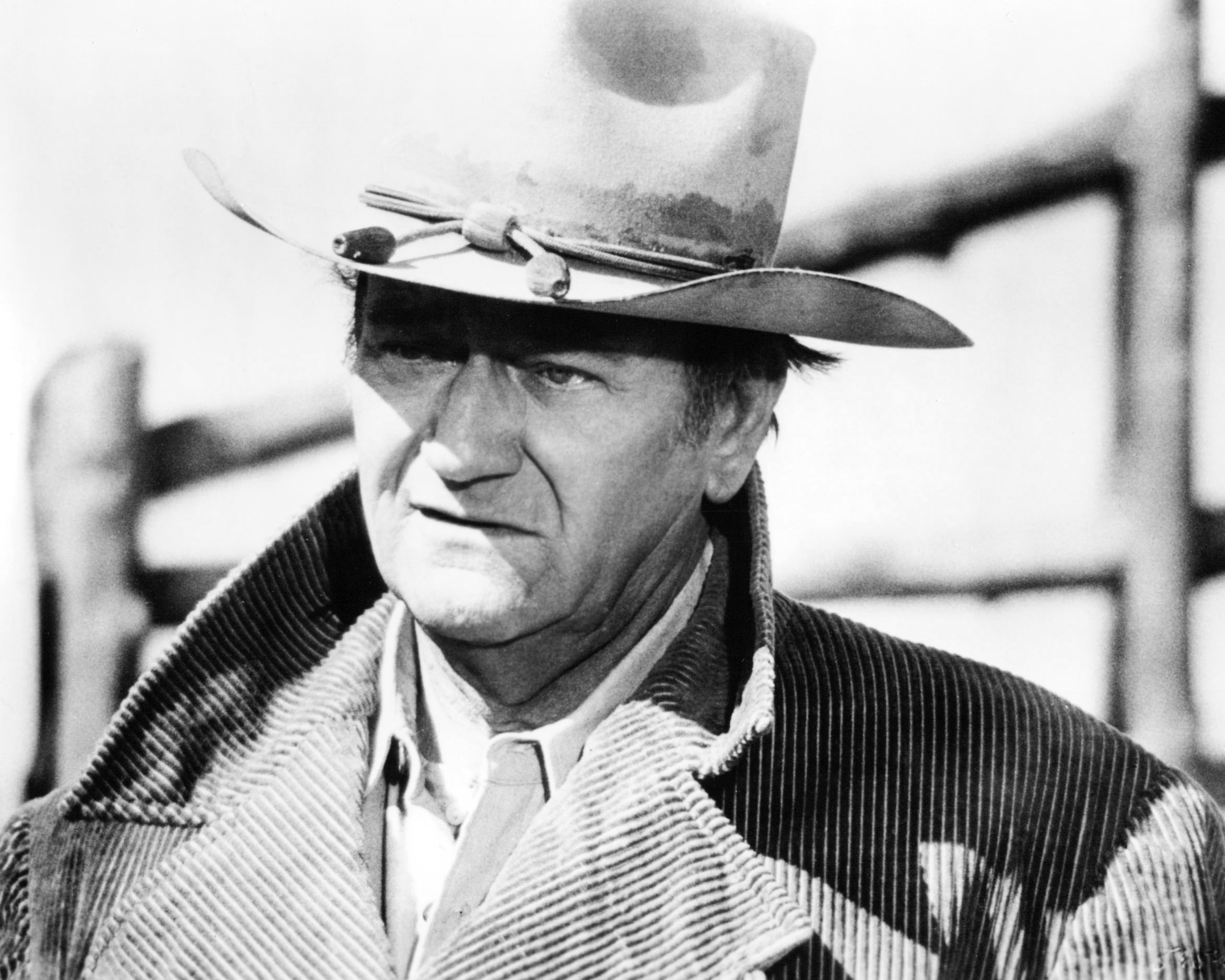 John Wayne near a fence