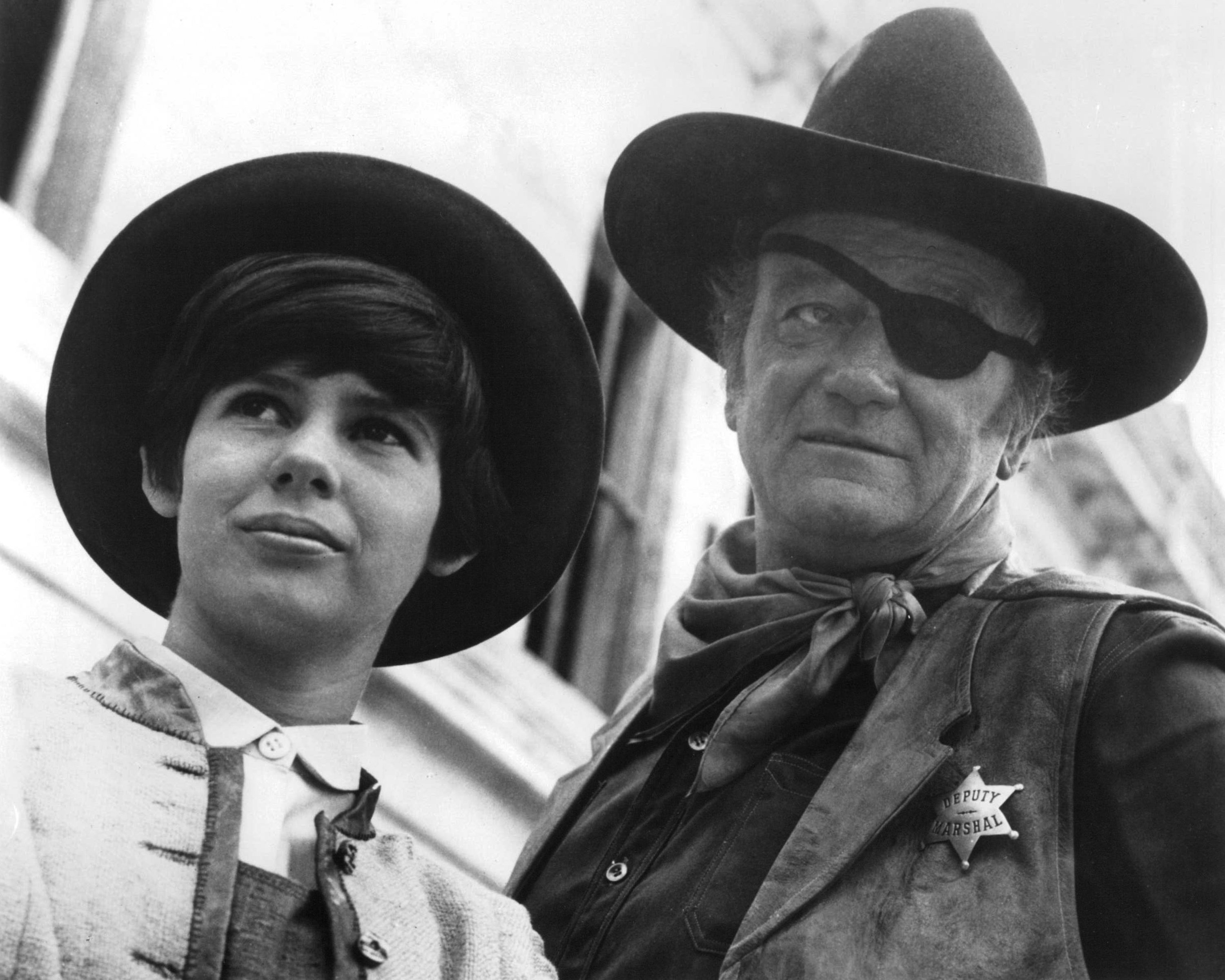 Kim Darby and John Wayne wearing cowboy hats