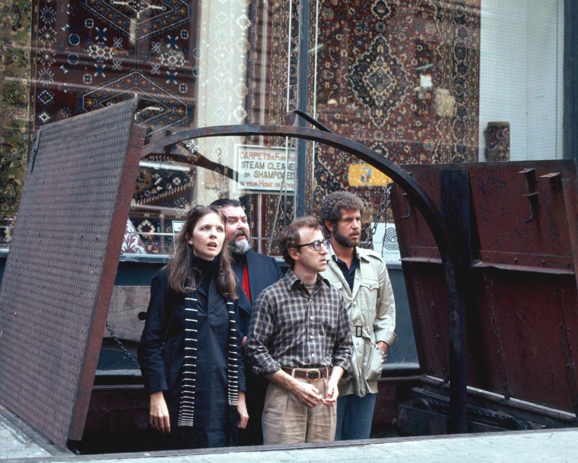 (L-R) Annie Hall, Woody Allen, Alvy Singer, and Tony Roberts standing in an outdoor basement entrance