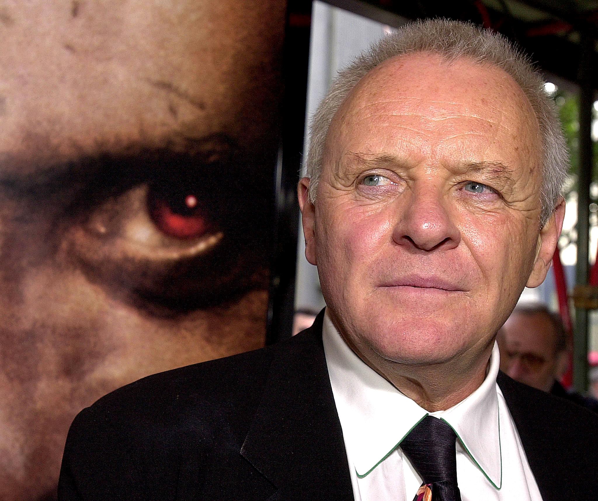 Anthony Hopkins next to a poster for the movie 'Hannibal'