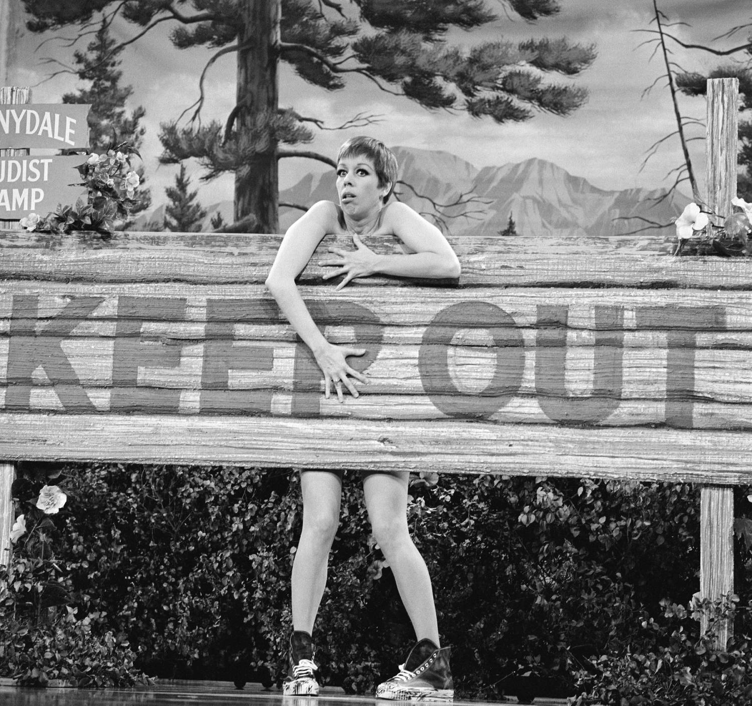 Seemingly naked, American comedienne and actress Carol Burnett hides behind a large wooden sign labelled 'Keep Out' during a skit on 'The Carol Burnett Show,' October 28, 1967.