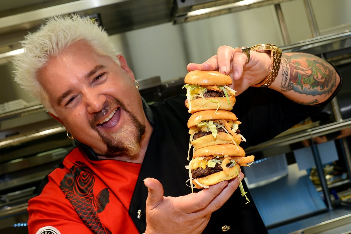 Chef and television personality Guy Fieri holds hamburgers in the kitchen during a welcome event for Guy Fieri's Vegas Kitchen & Bar at The Quad Resort & Casino on April 4, 2014 in Las Vegas, Nevada. The restaurant opens on April 17