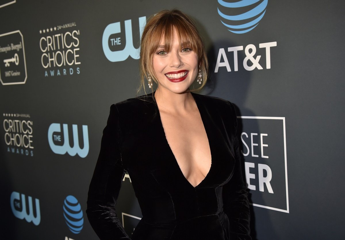 Elizabeth Olsen in front of a Critics' Choice Awards backdrop dressed in black