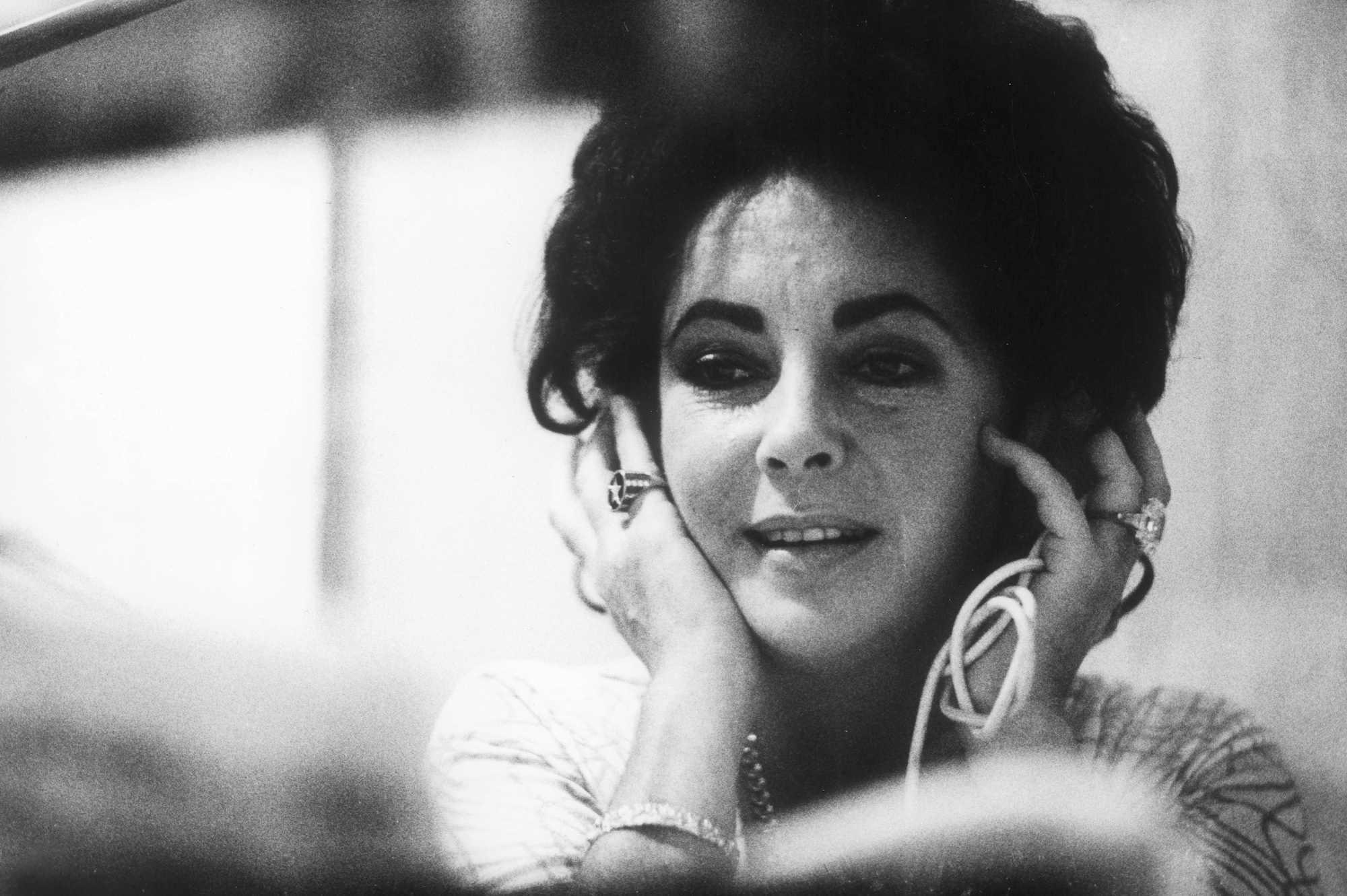 Elizabeth Taylor smiling, looking down, in black and white