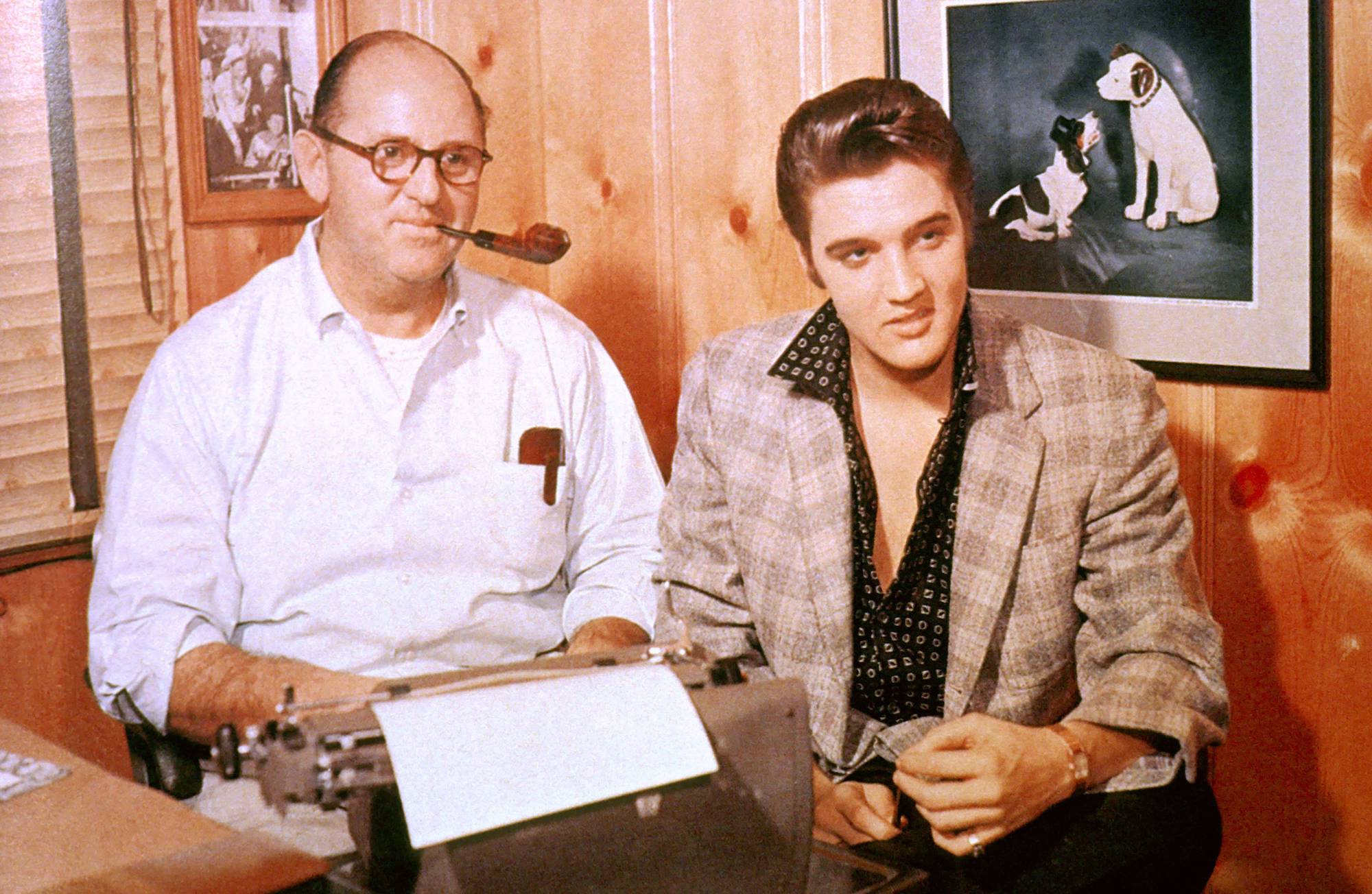 (L-R) Colonel Tom Parker, smoking a pipe, and Elvis Presley smiling