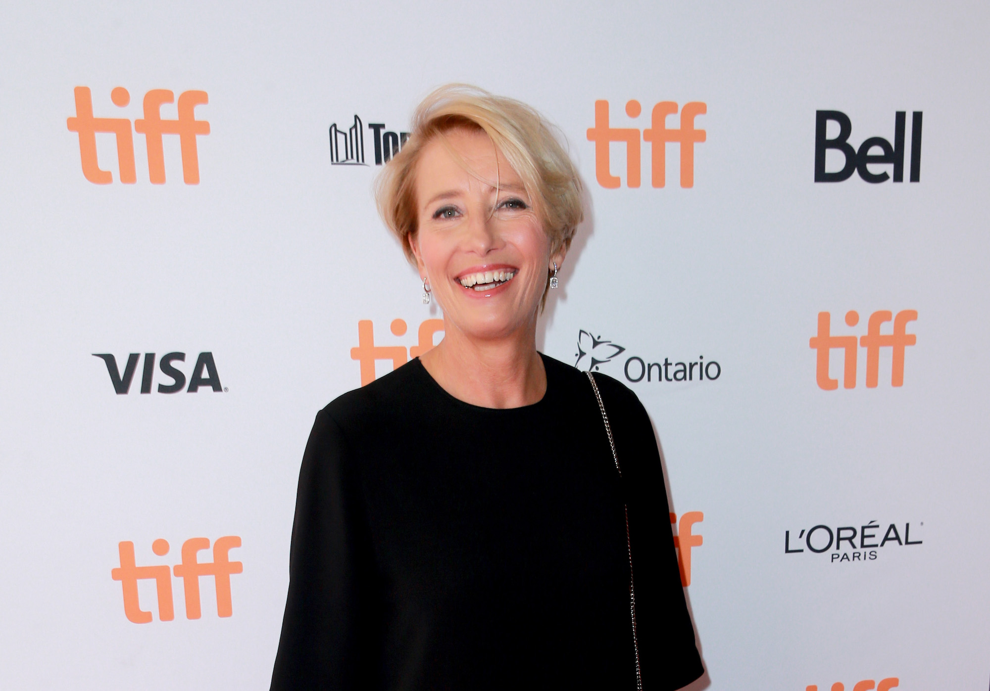 Emma Thompson smiling in front of a white background