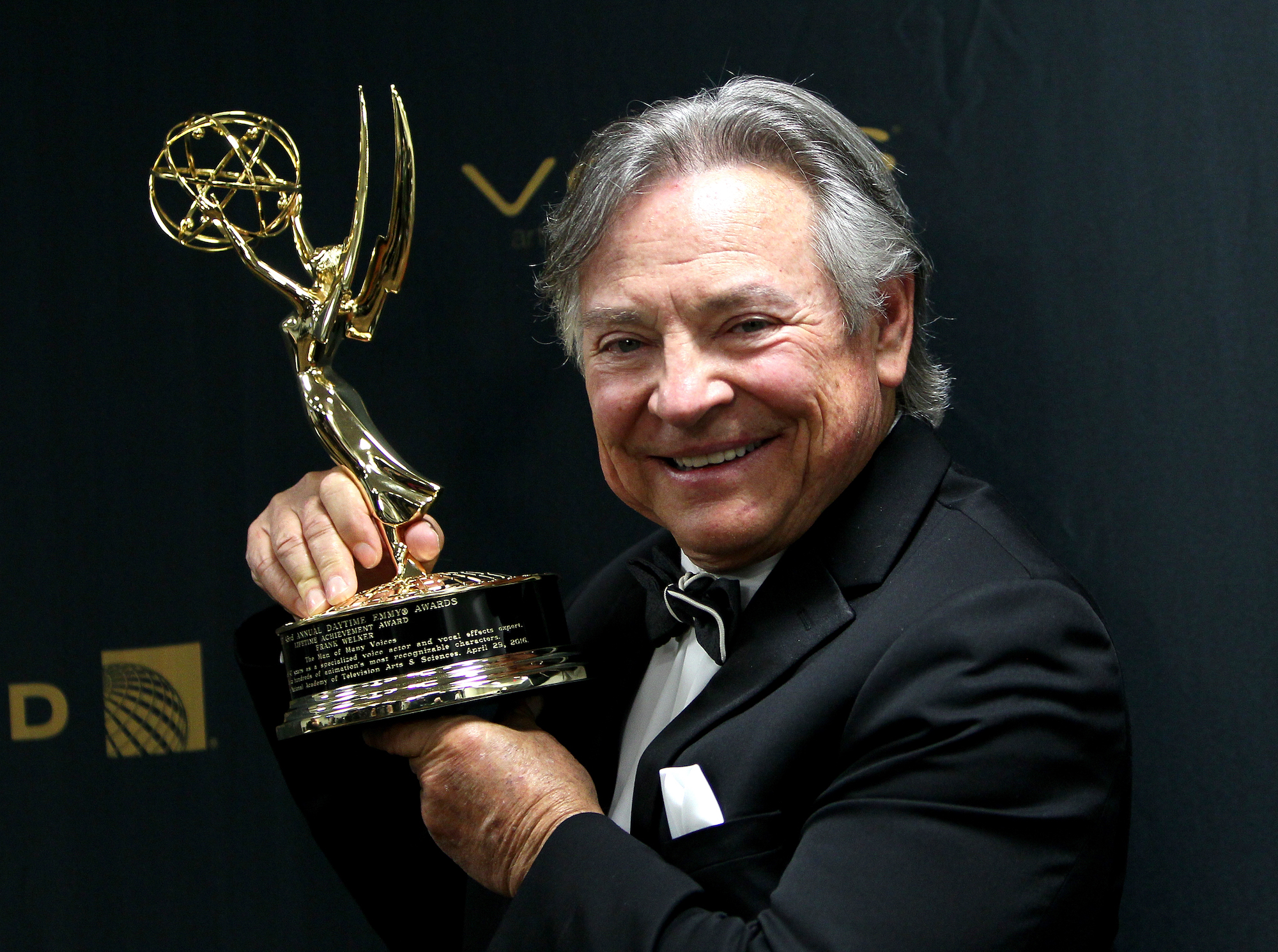 Frank Welker smiling, holding an Emmy Award