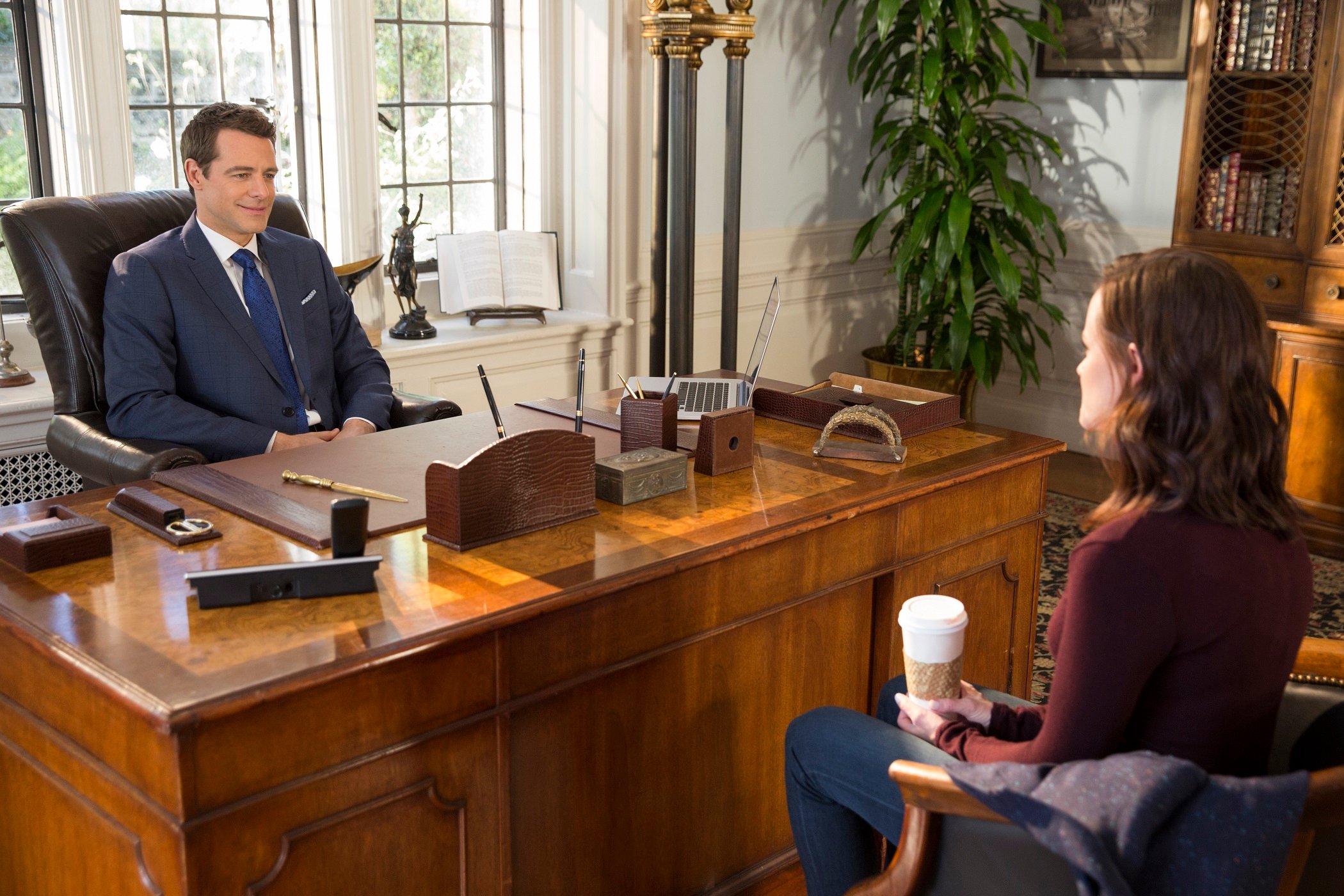 Christopher Hayden sits behind a desk and visits with Rory Gilmore in 'Gilmore Girls; A Year in the Life'