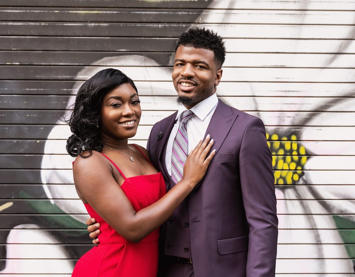 Chris poses in a suit and Paige poses in a red dress of Married at First Sight