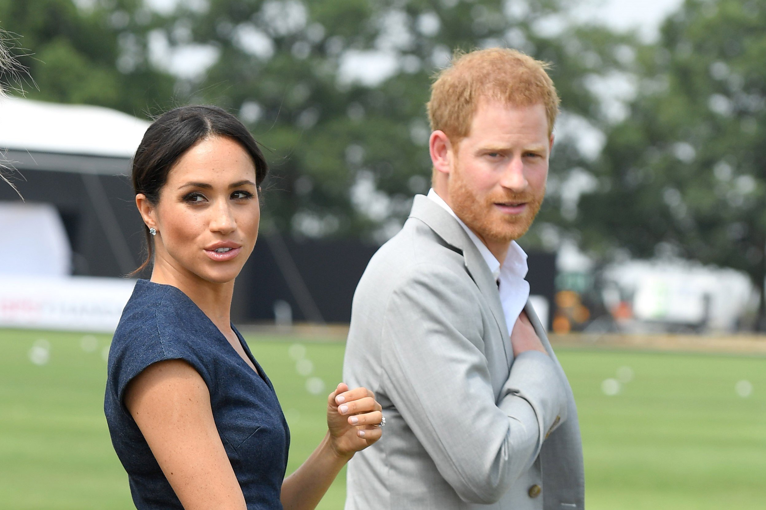 Meghan Markle and Prince Harry in front of a field
