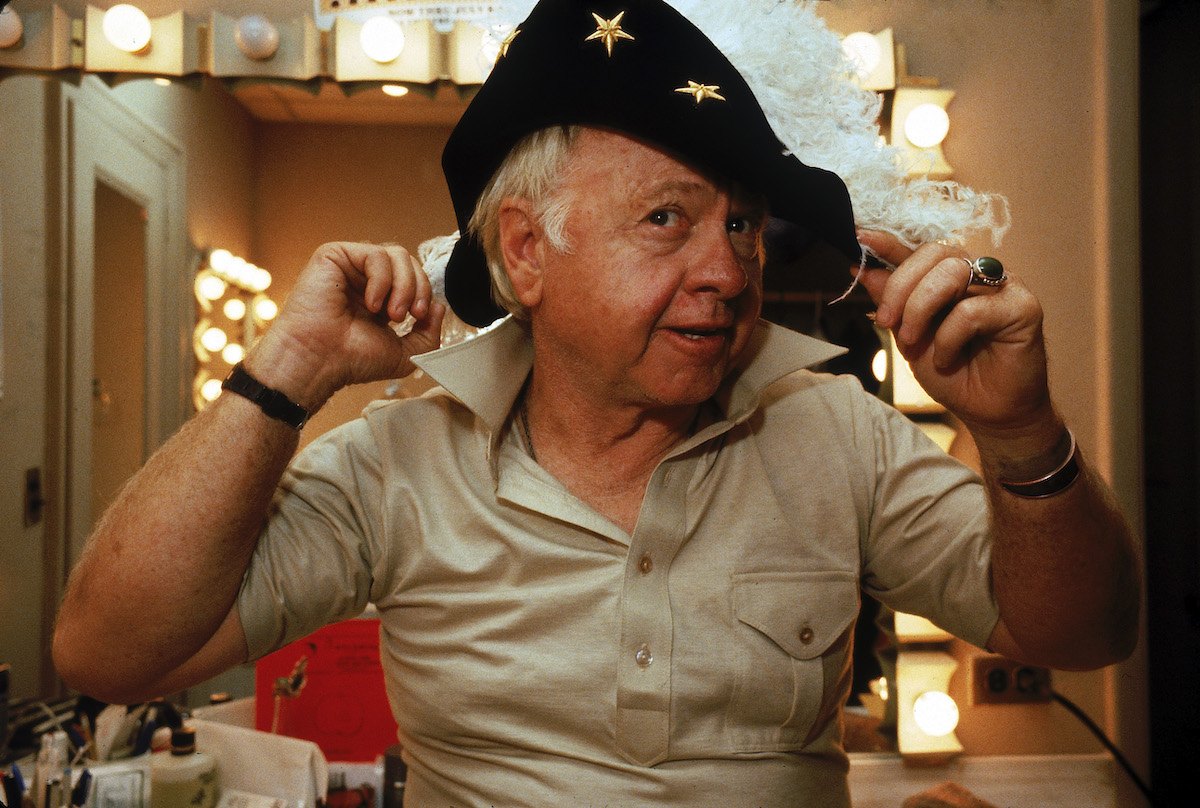 Mickey Rooney tries on a feathered hat in his dressing room in the Mark Hellinger Theatre