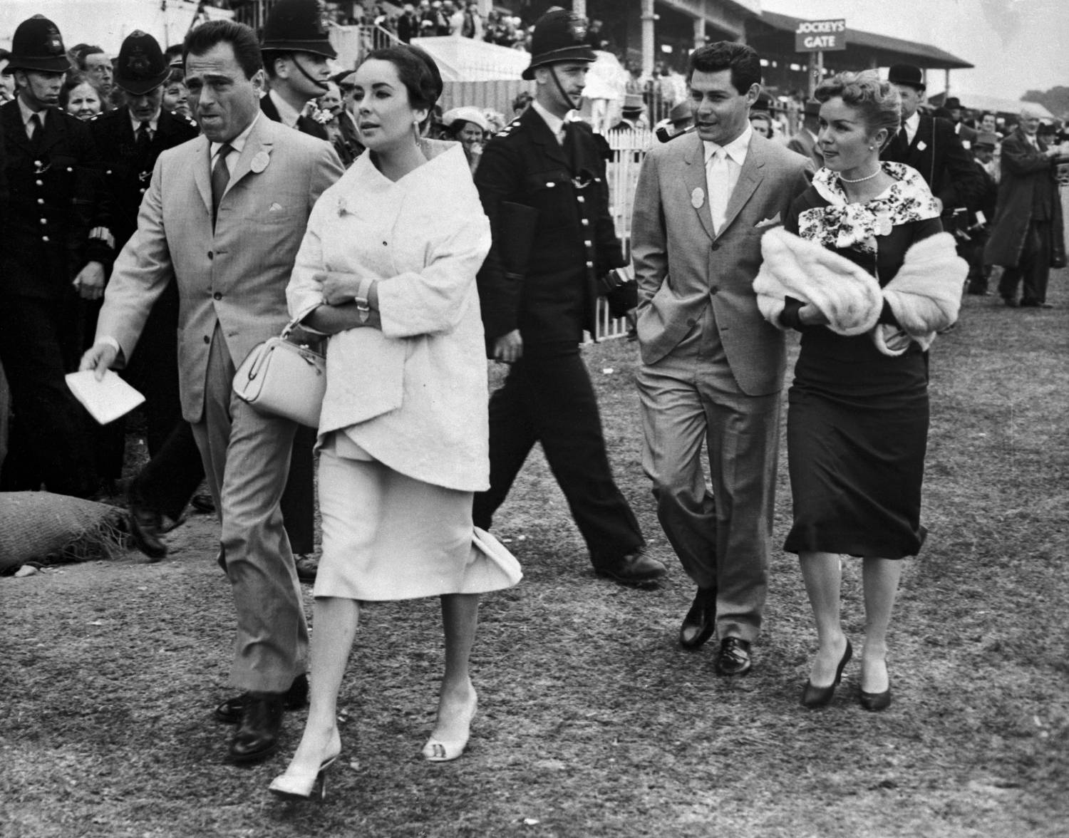 Actress elizabeth Taylor, who nearly died of pneumonia less than a year ago, was hospitalized late 2/17 with a throat hemorrhage, according to unconfirmed reports. In this June 5, 1957 photo, miss Taylor is shown with late husband, Mike Todd(left) as they attended the running of the English Derby in Epsom. They are followed by singer, Eddie Fisher, and his wife, Debbie Reynolds.