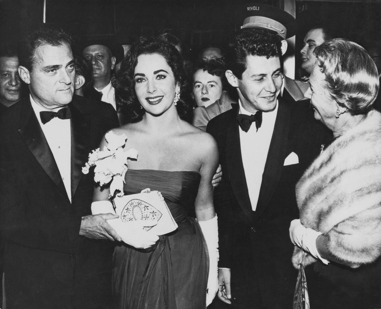 Actress Elizabeth Taylor at an event with her husband film producer Mike Todd (left), and singer Eddie Fisher, circa 1957.
